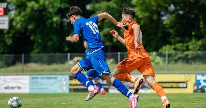 man in blue and orange jersey shirt running on green grass field during daytime